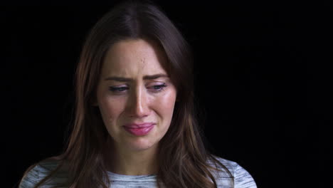 close up of unhappy young woman crying into camera