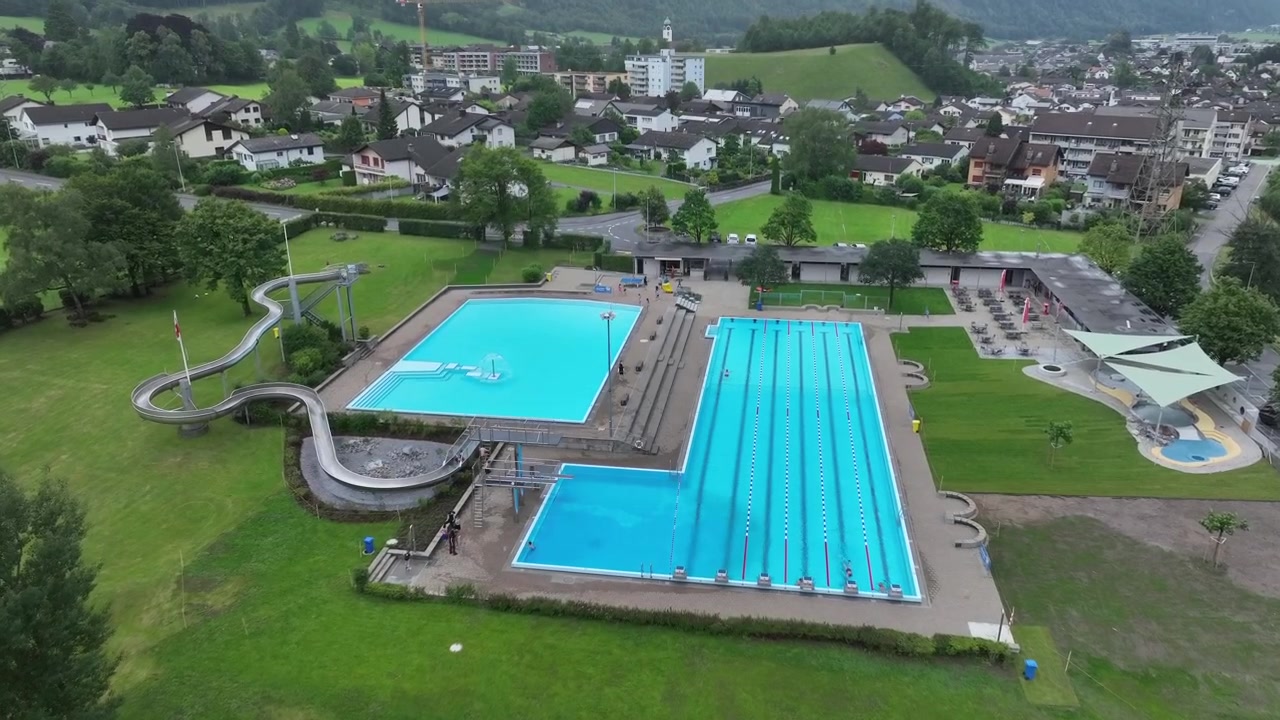 Luftfoto over swimmingpool og vandrutsjebane på en schweizisk feriecampingplads.