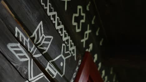 close up angled moving shot of ornamental traditional slovakian symbols are painted on a wooden rural village house in čičmany, slovakia, worlds cultural heritage, a famous landmark in central europe