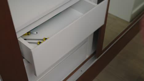 man opens drawer and grab the tools