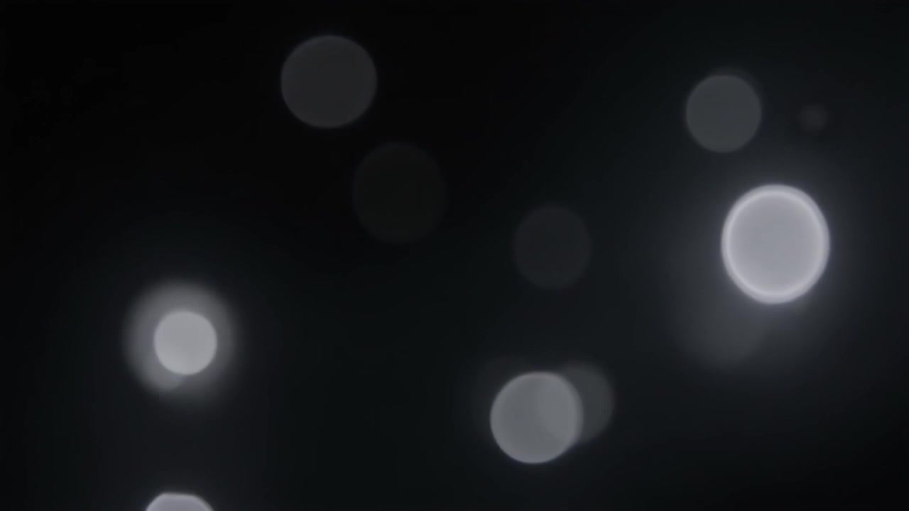 Abstract White Bokeh Lights Floating on Dark Background