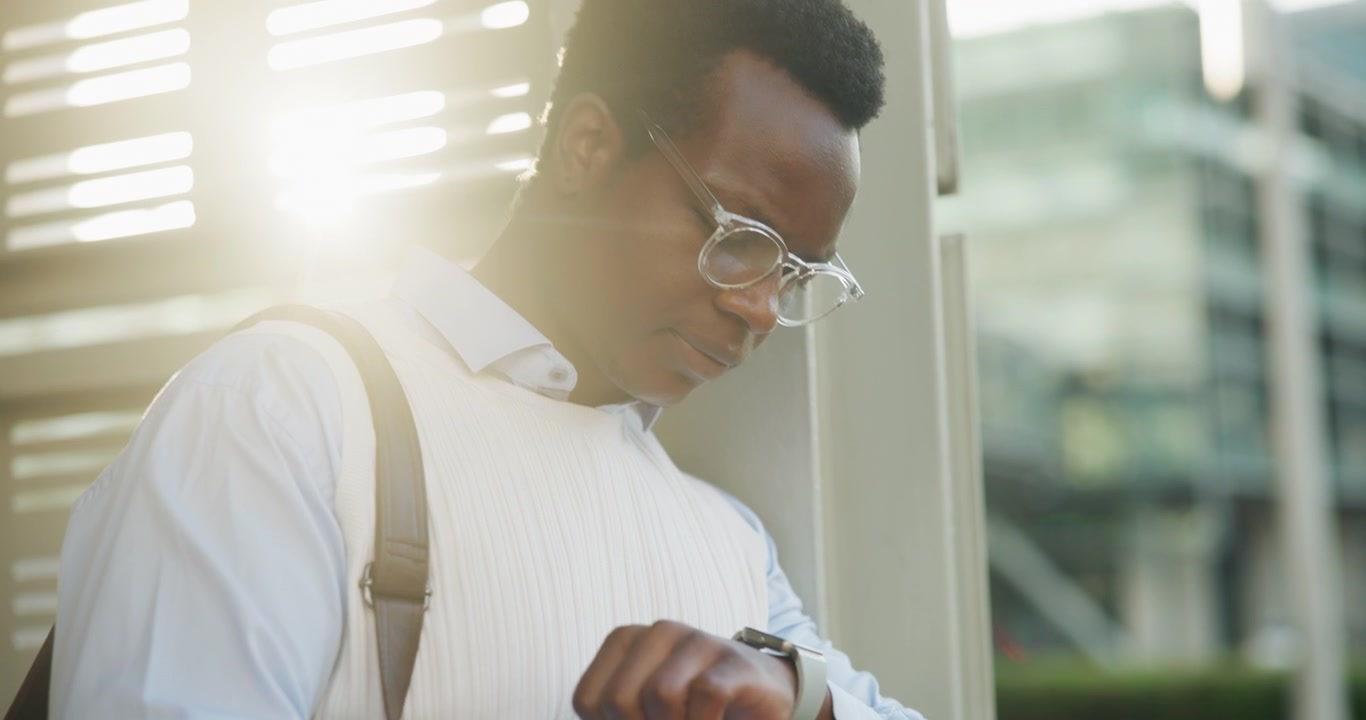 Young Professional Man Checking Time on Smartwatch Outdoors