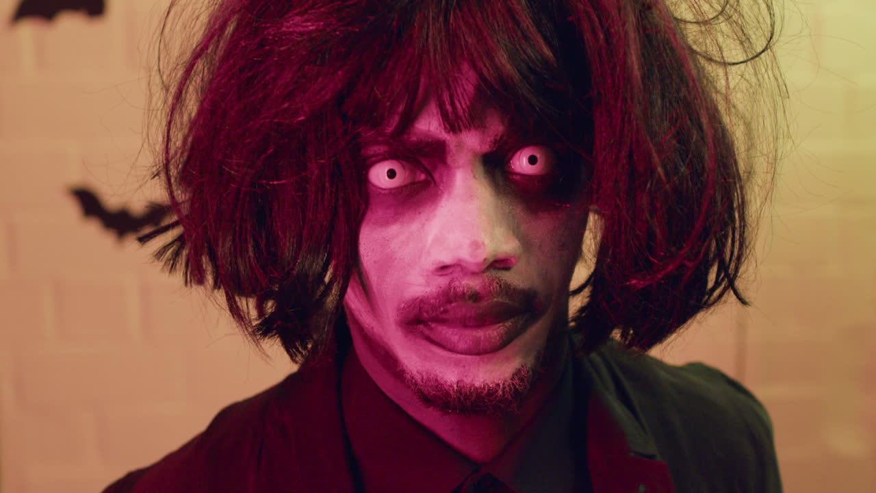 мужчина показывает зубы на камеру на вечеринке на хэллоуин.