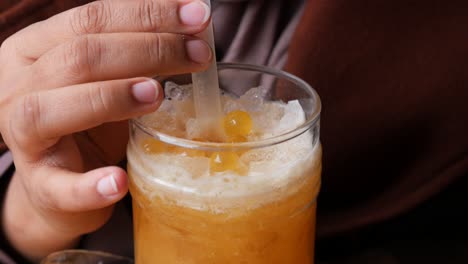 cerca de una persona sosteniendo un vaso de té de burbujas con una pajita