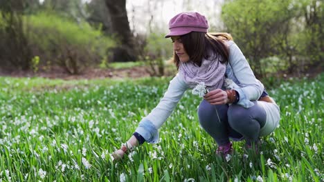 Mujer-Recogiendo-Flores-De-Lirio-Blanco-De-Los-Valles-En-Un-Parque-Recogiéndolas-En-La-Mano