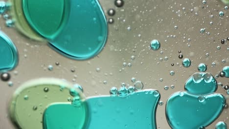 close-up of blue and green liquid with floating bubbles and blobs in motion inside a lava lamp, viewed in a horizontal orientation. hypnotic and abstract visual texture