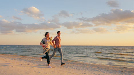 young couple running along the seashore at sunset the concept - a happy honeymoon the energy of yout