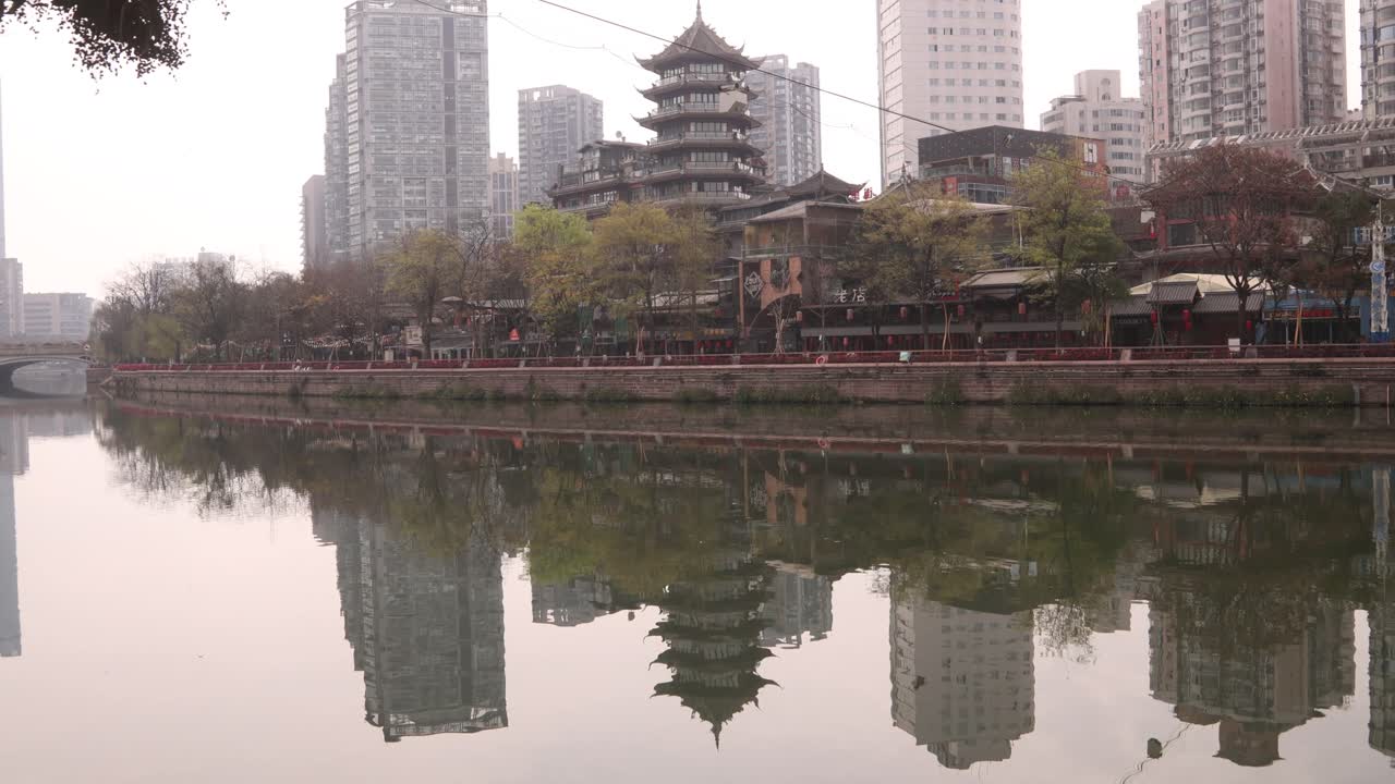 ancient and modern skyline architecture building in Chengdu capital city of the Chinese province of Sichuan, reflection on the Jin river, tilt up cityscape cloudy day