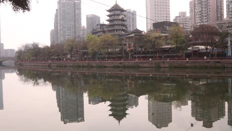 ancient and modern skyline architecture building in chengdu capital city of the chinese province of sichuan, reflection on the jin river, tilt up cityscape cloudy day
