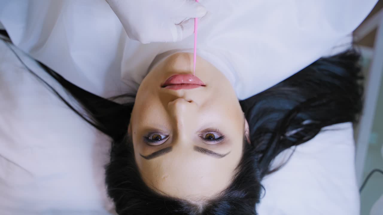 Make up for lips of woman. Young woman having makeup on lips at beauty salon