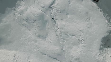 bird's eye view of a man trudging through the snow in the mountains