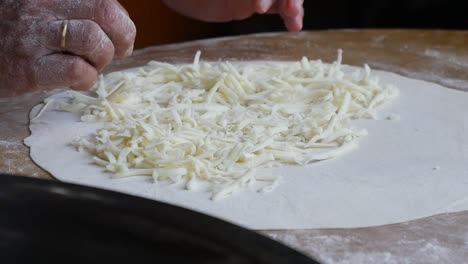 preparing a flatbread with cheese