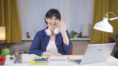 Female-student-waving-to-the-camera.