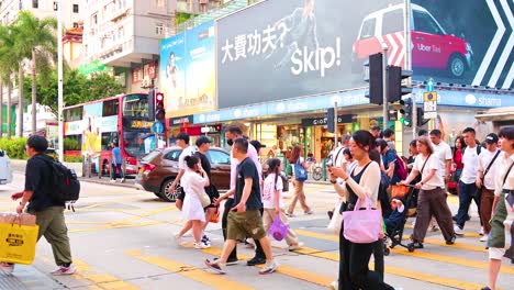 people crossing a bustling street in hong kong