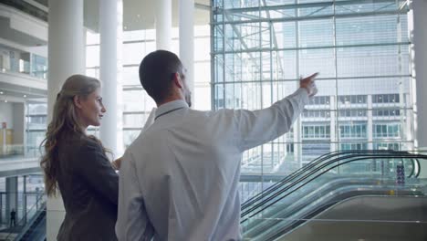 male and female architects discussing over blueprint in office 4k