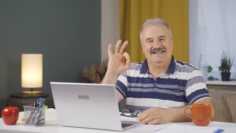home office worker old man making positive gesture at camera.