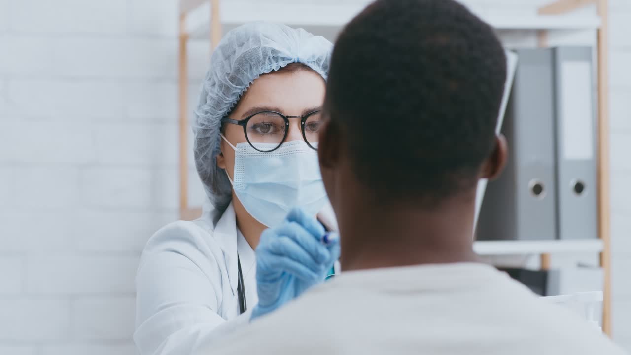 Medico che esegue un tampone faringeo su un paziente