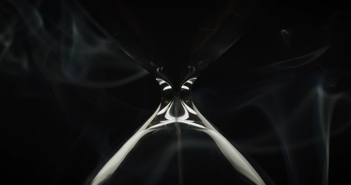 Smoke wraps an hourglass with black sand