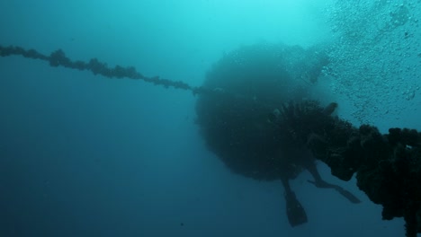 commercial scuba divers work on an man-made underwater structure deep below the ocean surface