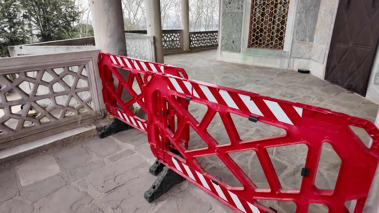 Barreras de construcción rojas y blancas en un patio de piedra