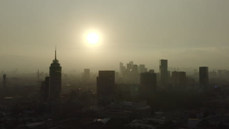 Aerial-shot-of-the-Mexico-City-center-skyline,-with-sun-backlight