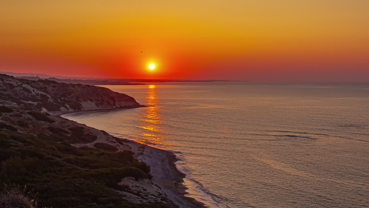 un horizonte rojo ardiente cambia a amarillo durante un amanecer sobre el mar