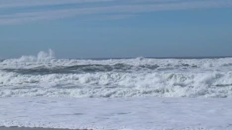 White-capped-waves-crashing-at-shoreline-on-the-beach-in-Nazare,-Portugal