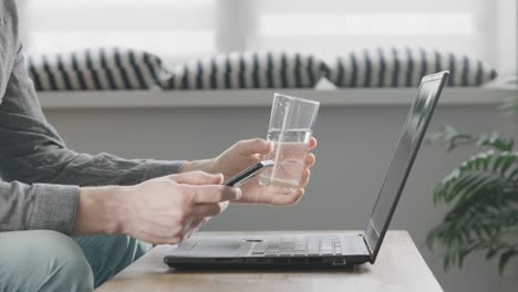 an unrecognizable man uses mobile internet from his smartphone to work on a laptop