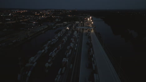 aerial view of the dimly lit melnik river port with containers and spreaders working the night shift