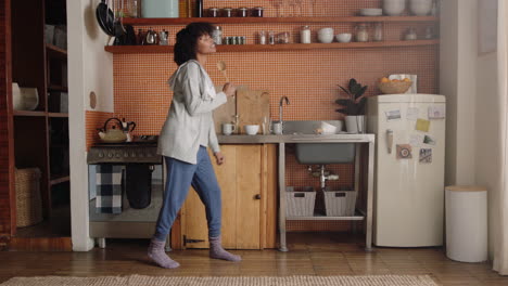 happy woman dancing in kitchen celebrating successful lifestyle enjoying cheerful victory dance celebration