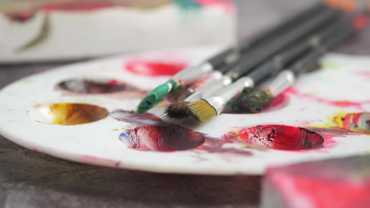 Primo piano di tavolozza di colori e pennelli con colori vivaci