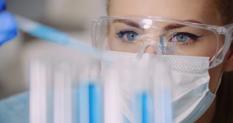 doctor carefully drips medicine from pipette into sample glass tubes for dna analysis at laboratory 5