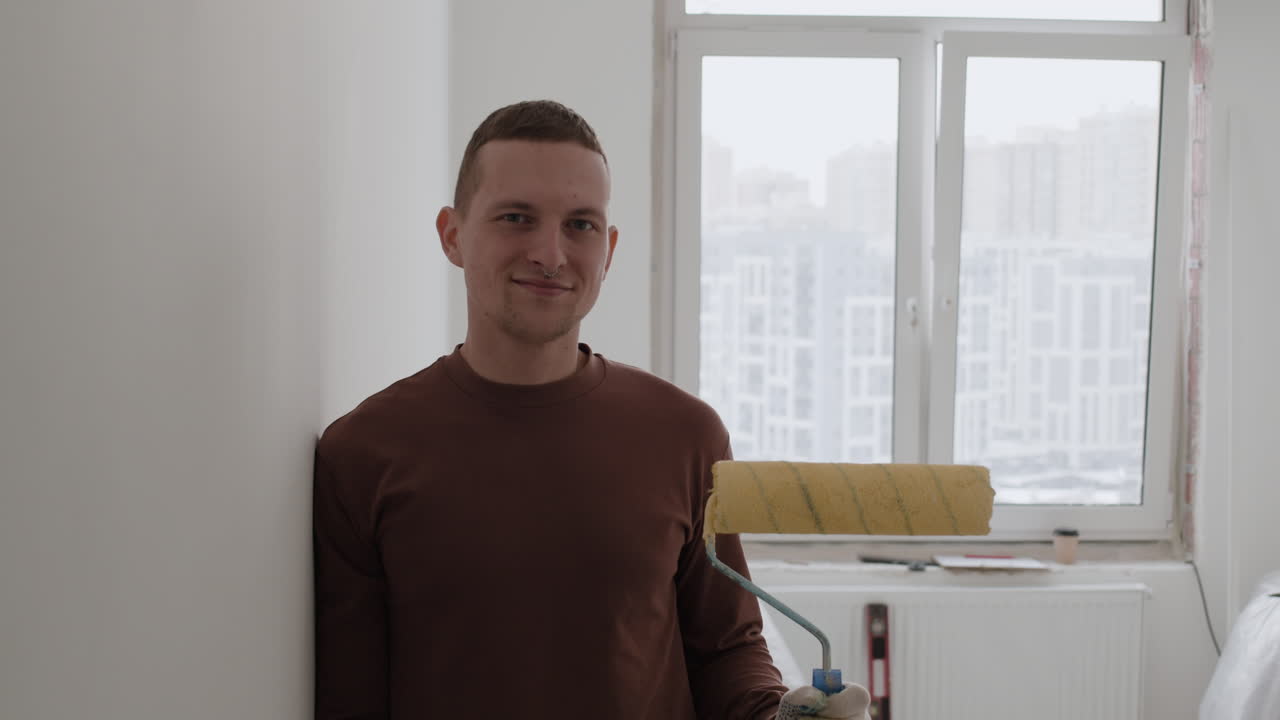 Happy Painter in Brown Long-Sleeve Shirt with Paint Roller, Home Renovation