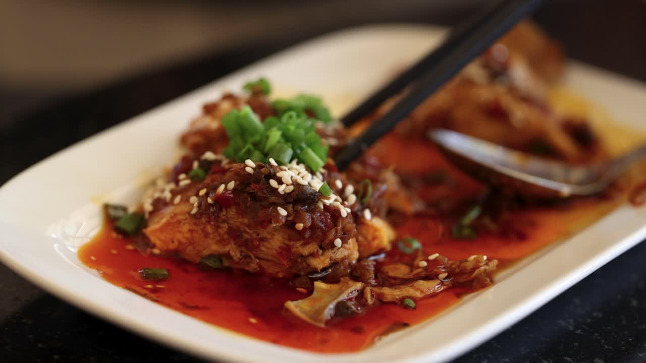 los palillos levantan un sabroso plato asiático adornado con hierbas y semillas de sésamo, mostrando colores vibrantes y texturas ricas