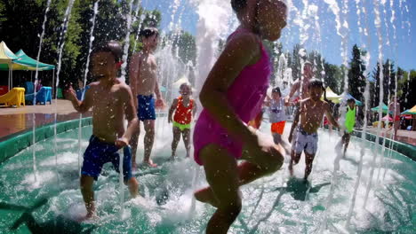 children playing in a water fountain