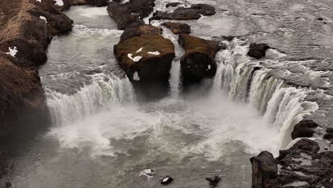 scenic aerial view of goðafoss waterfall in northern iceland, with its iconic semi-circular shape and powerful river flow through basalt formations