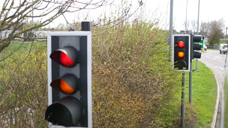 los semáforos del reino unido cambian de rojo a verde en una carretera desde una ventana de autobús
