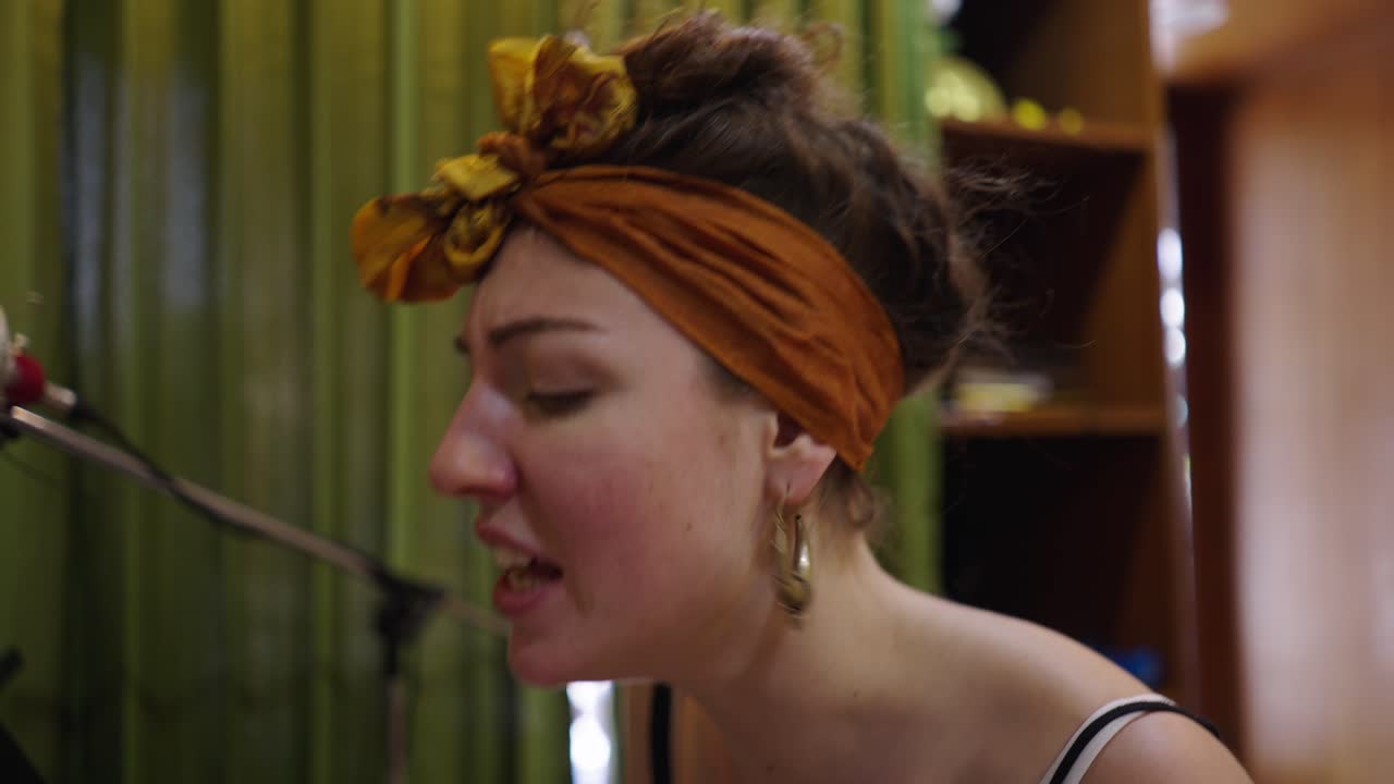 A woman singing and performing in a music studio