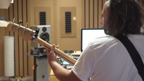 bass guitar player in recording studio, back view