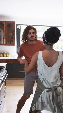 vertical video: couple in kitchen, man holding woman's hand, engaging in conversation