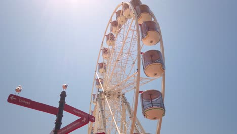 Ferris Wheel in Sydney and direction signs at Darling Harbour Australia.. Slow tilting close up