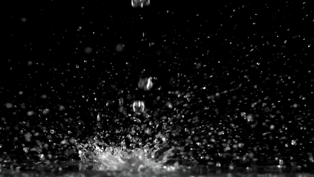 暗い表面に飛び散る水滴のスローモーション