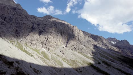 imágenes aéreas de drones girando lentamente para revelar una cresta espinosa y cumbres montañosas en la cima de imponentes acantilados en un valle glacial en suiza