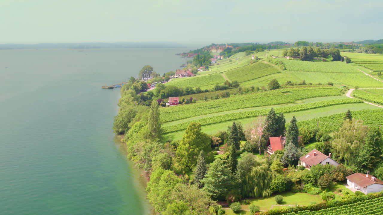 Frugtplantager skråner ned mod kystlinjen på en tåget dag, Meersburg, Tyskland