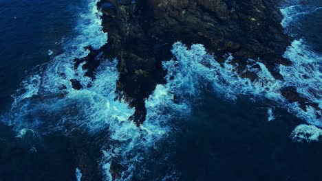 Fotografía-Cenital-De-Pequeñas-Olas-Que-Salpican-Suavemente-Las-Rocas-En-Los-Cristianos,-Tenerife