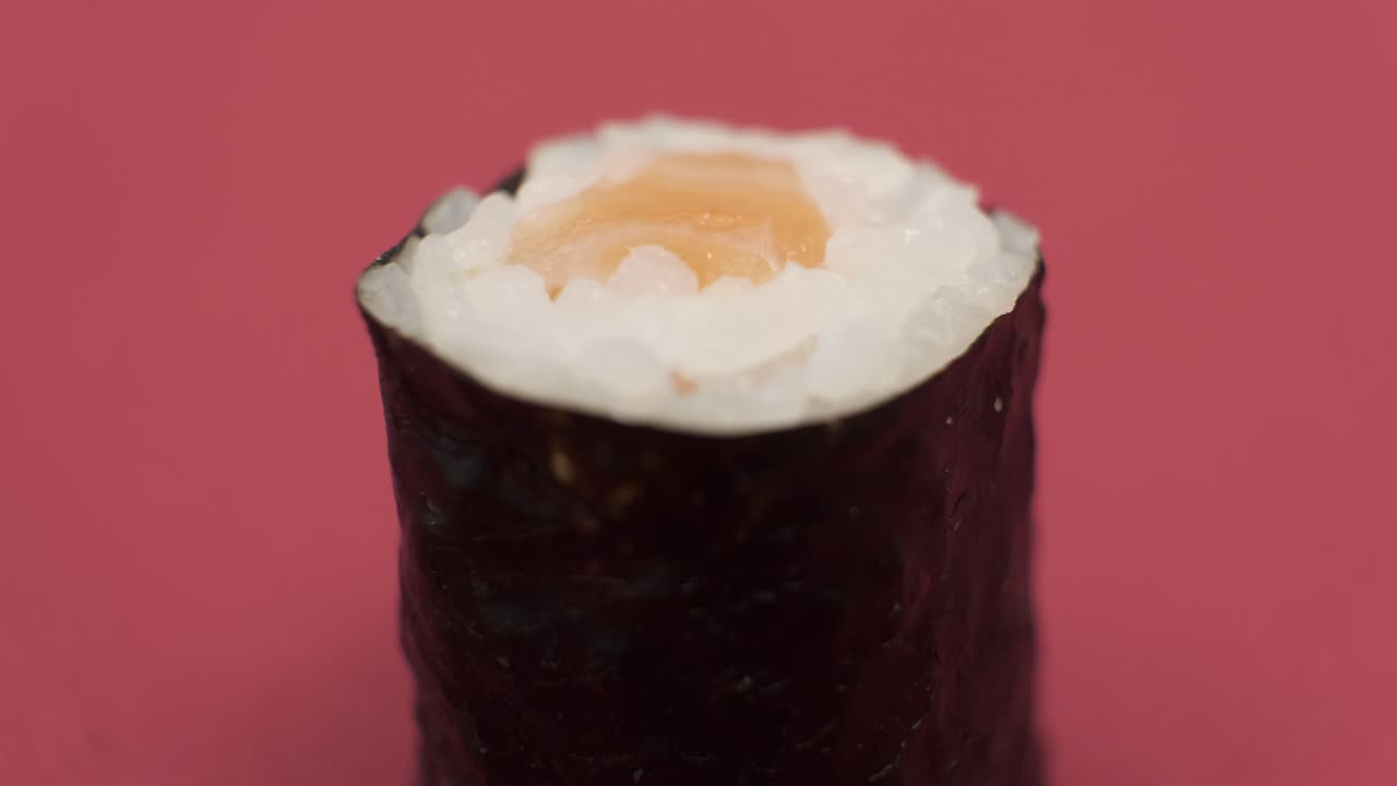 un rollo de sushi girando sobre un fondo rojo