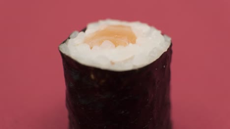 Sushi-roll-rotating-on-red-background