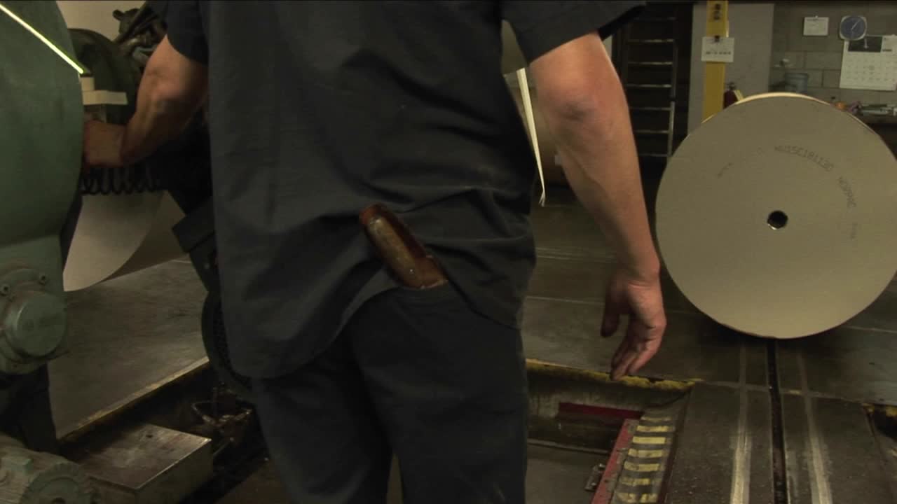 trabajadores cargan periódicos en una fábrica de papel