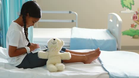 girl using digital tablet on bed