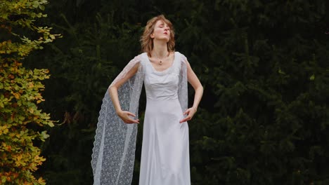 Woman-in-a-beautiful-long-white-dress-dancing-outside